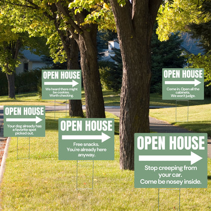 Multiple open house signs in a grassy area with trees
